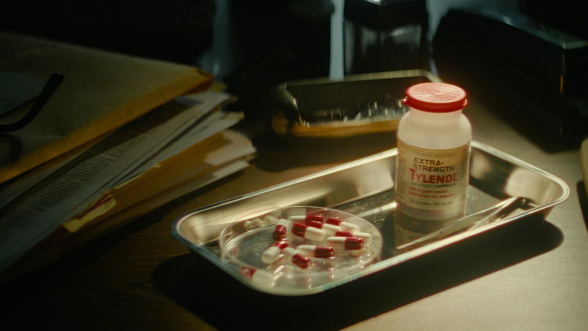 A tray of Tylenol pills next to a bottle.