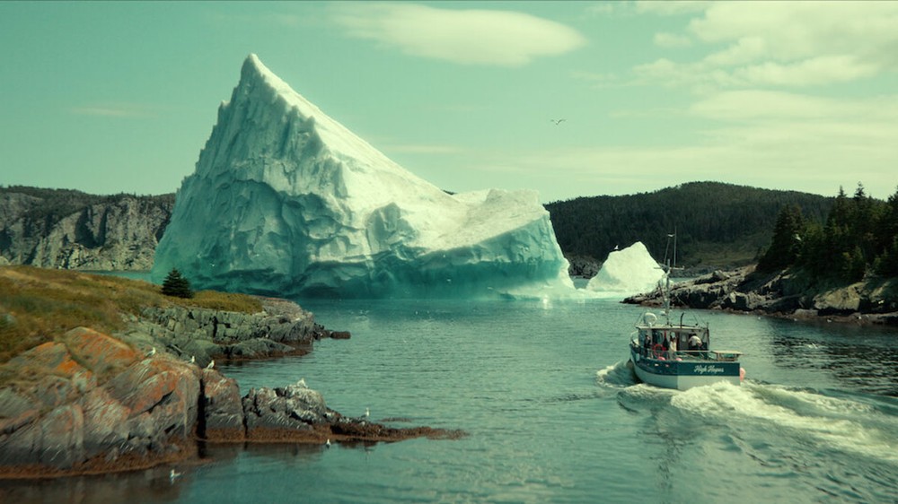 Ao mover o iceberg usando um barco em Profundezas, Calvin acaba salvando a criatura de ser bombardeada pelos militares — Foto: Reprodução/Netflix