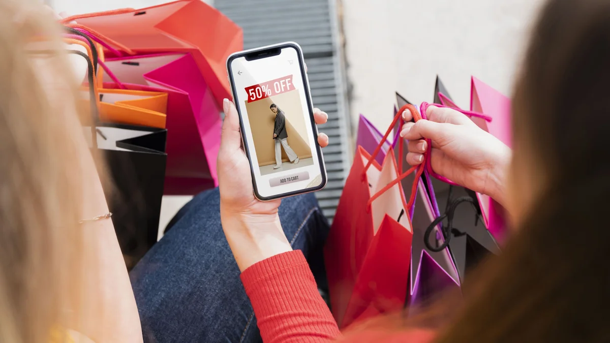 mulher visualziando uma oferta no celular e segurando sacolas de compras